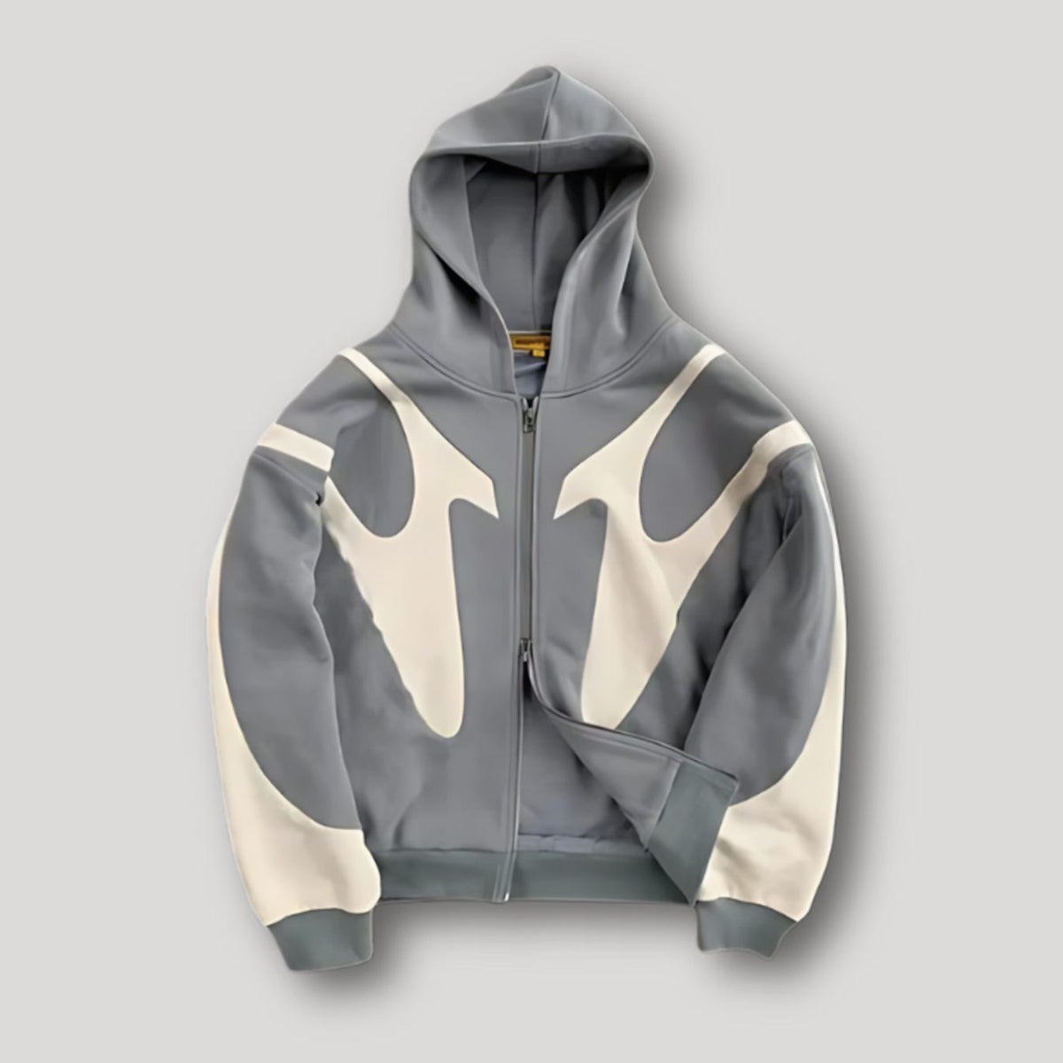 Hombre luciendo sudadera streetwear oversize con capucha y panel de contraste gris