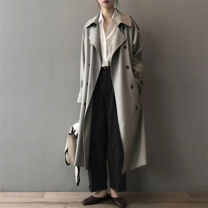 Mujer luciendo trench largo cruzado con cinturón ajustable en color gris