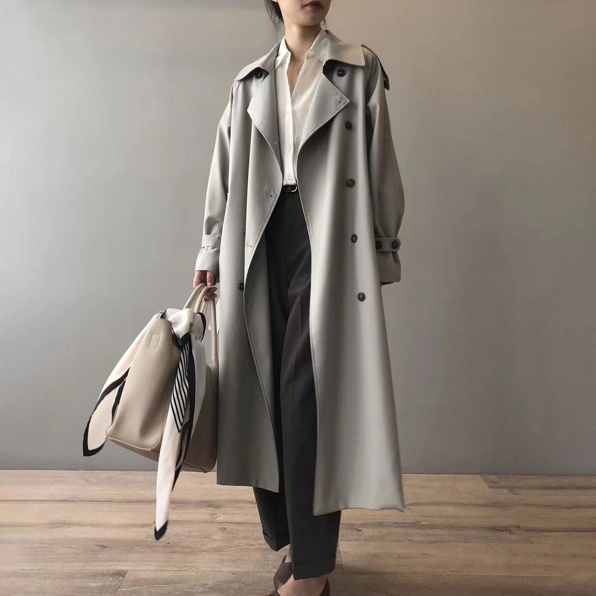 Vista frontal del trench coat con botonadura doble y solapas clásicas