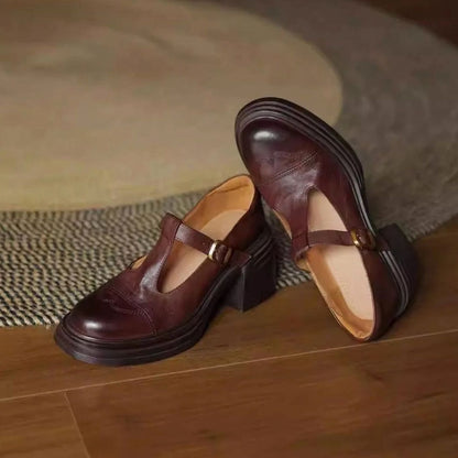 Detalle de la hebilla dorada en los zapatos de piel con tira en T