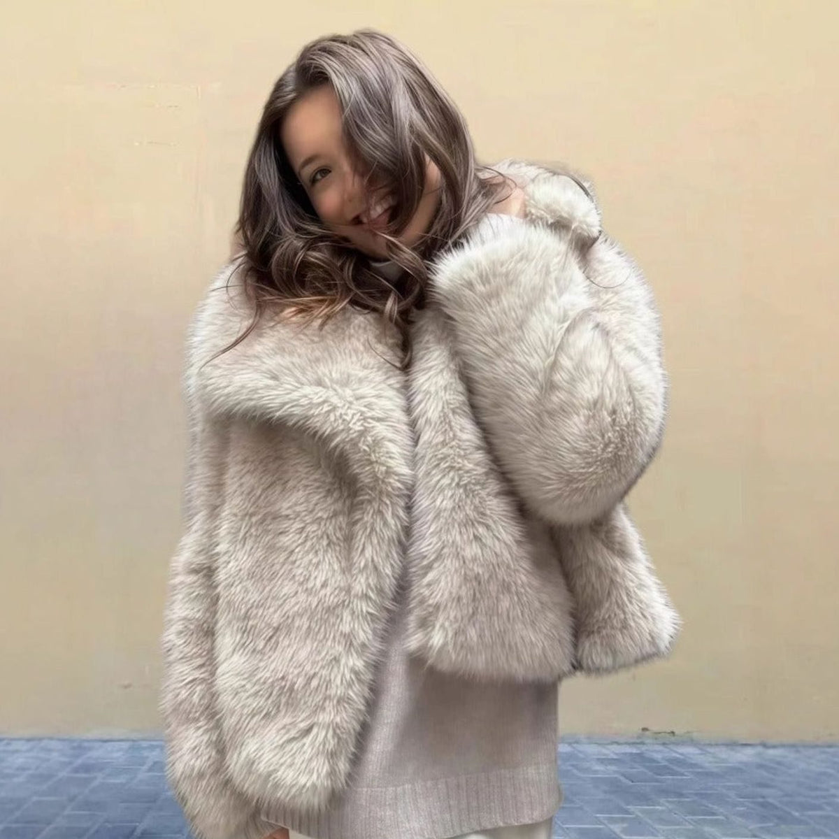Mujer luciendo el abrigo corto de pelo sintético en look urbano de invierno