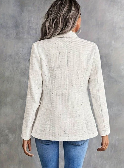 Detalle de la solapa de pico y los botones dorados de la blazer de tweed