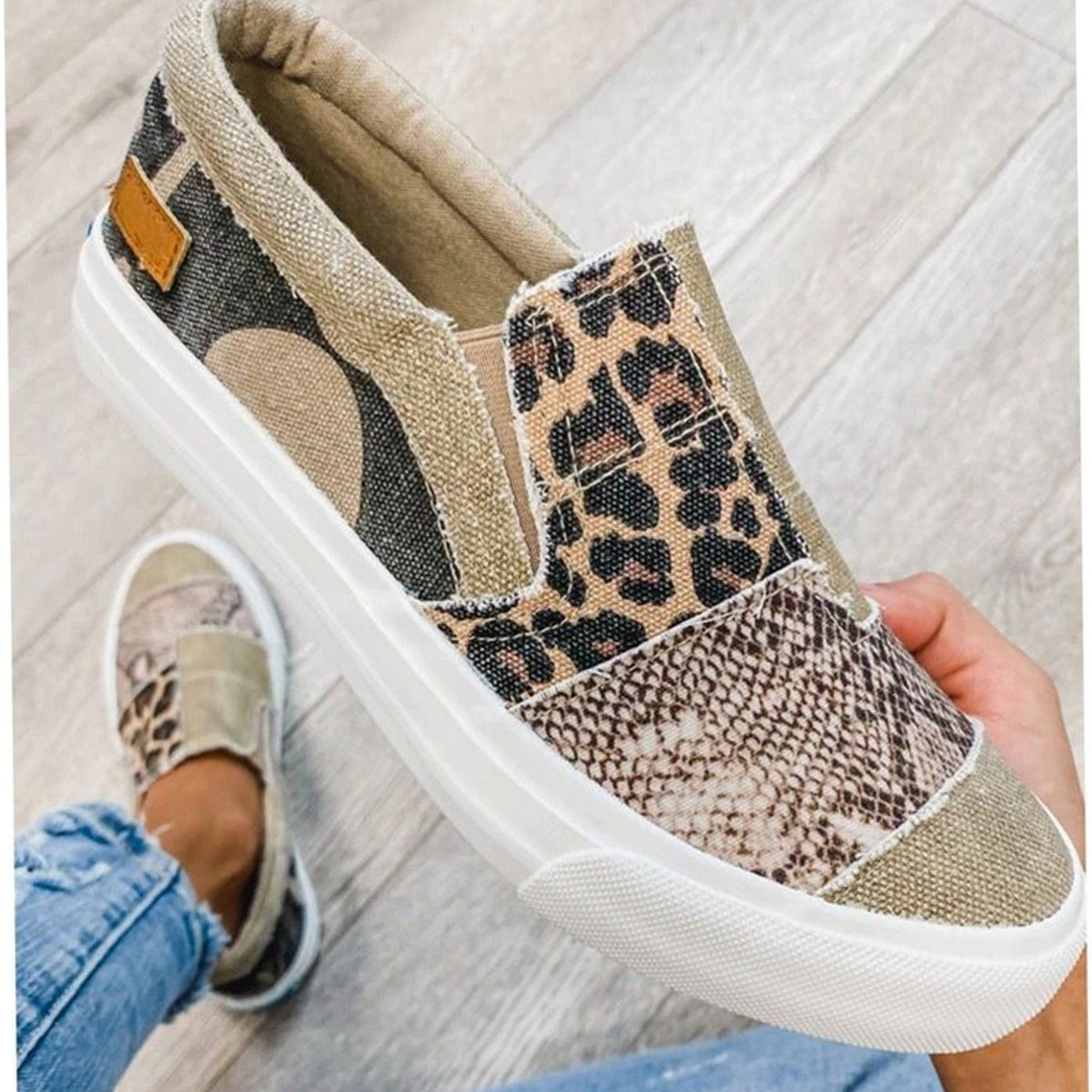 Par de zapatillas de lona con estampado animal print sobre fondo neutro