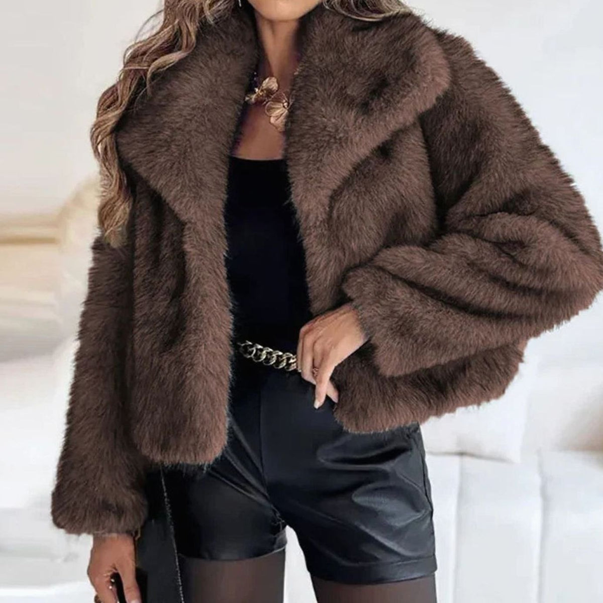 Chaqueta corta de pelo sintético combinada con vestido para un look de noche