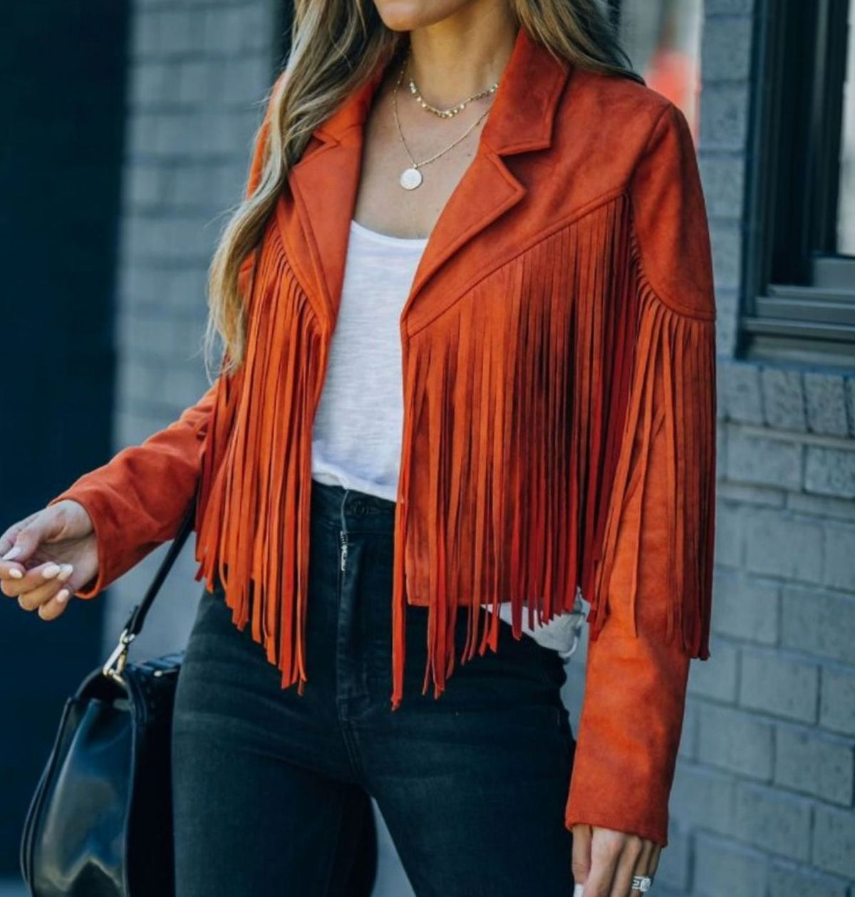 Mujer con chaqueta corta de ante con flecos estilo motero