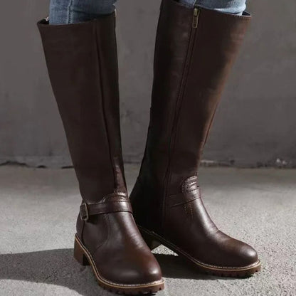 Detalle de la hebilla dorada envejecida en botas altas de mujer
