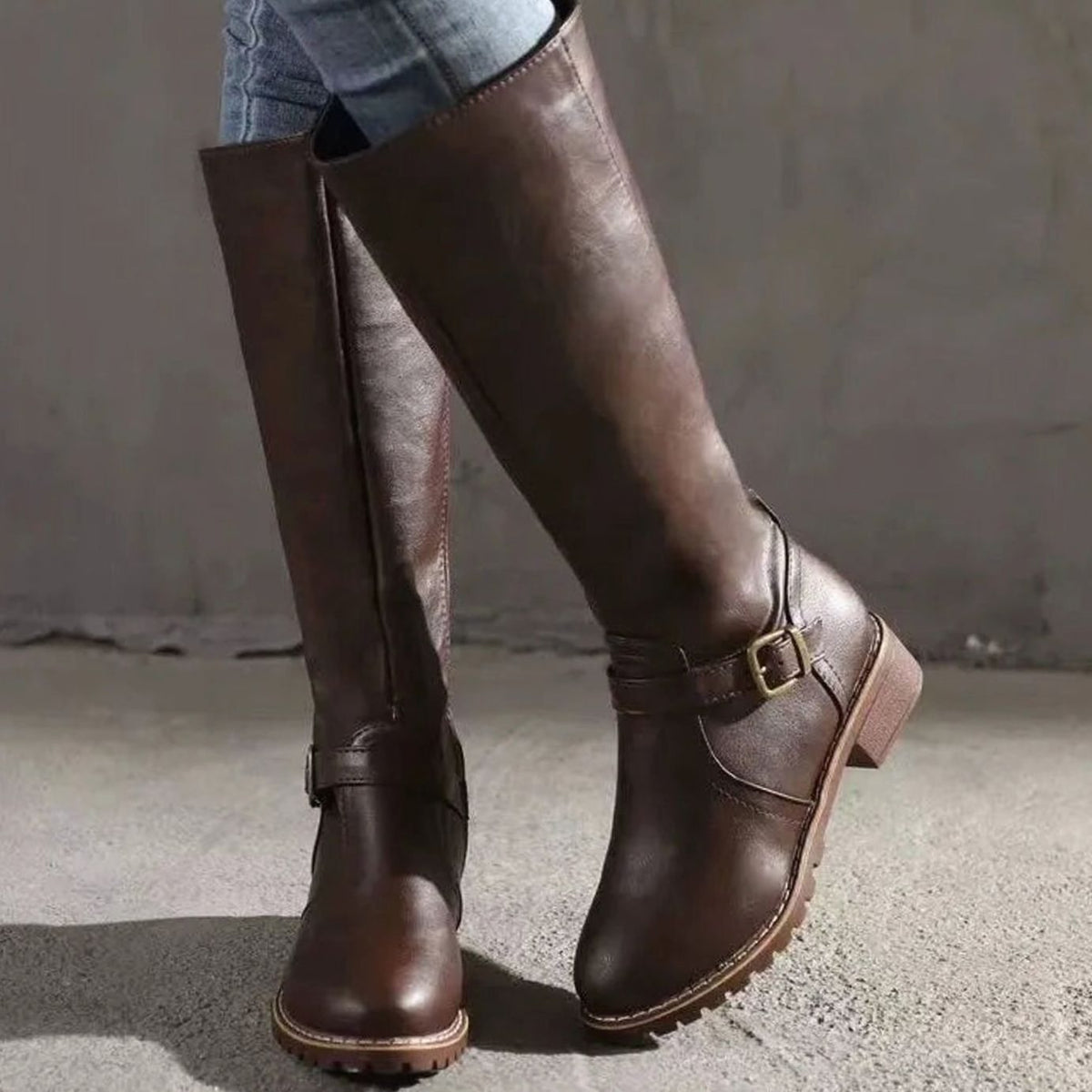 Botas altas de piel negra hasta la rodilla combinadas con vaqueros