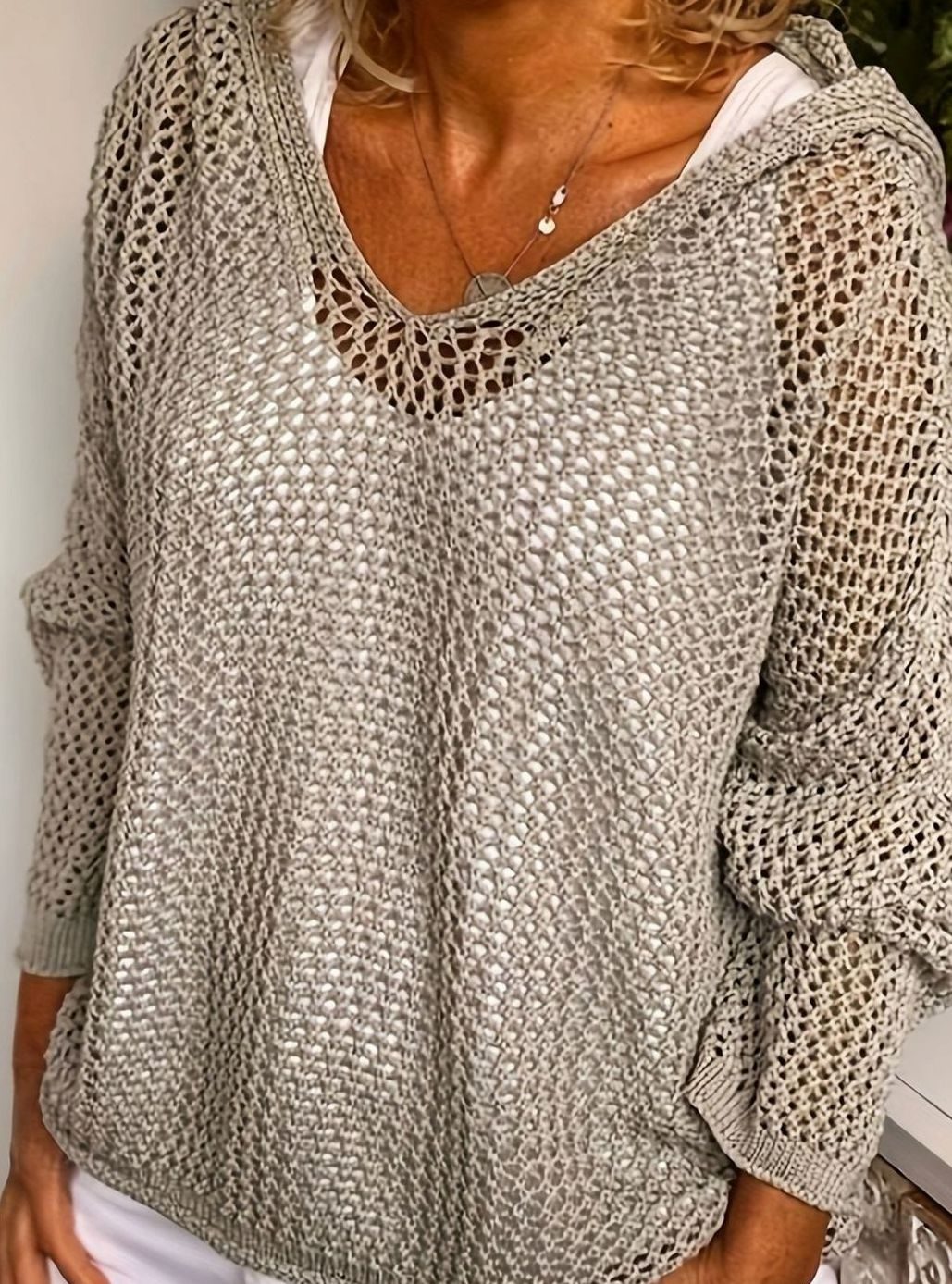 Mujer con jersey de punto calado y capucha en ambiente casual