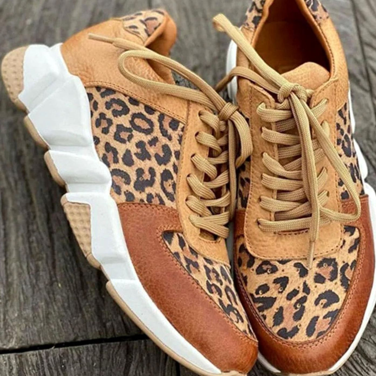 Vista lateral de zapatillas chunky con suela blanca acolchada y estampado leopardo