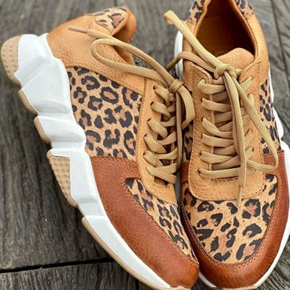 Vista lateral de zapatillas chunky con suela blanca acolchada y estampado leopardo