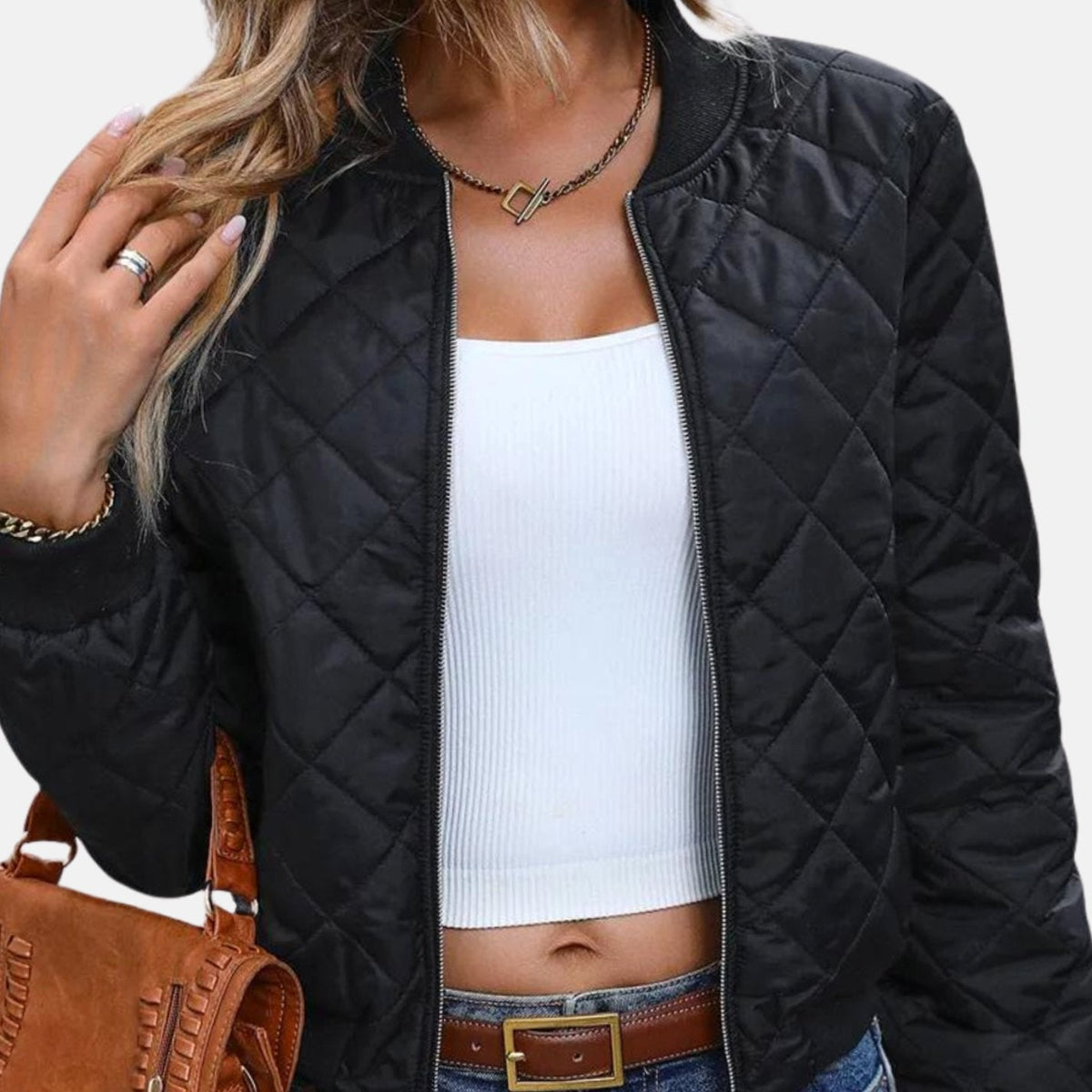 Mujer luciendo la cazadora bomber cropped acolchada negra combinada con vaqueros