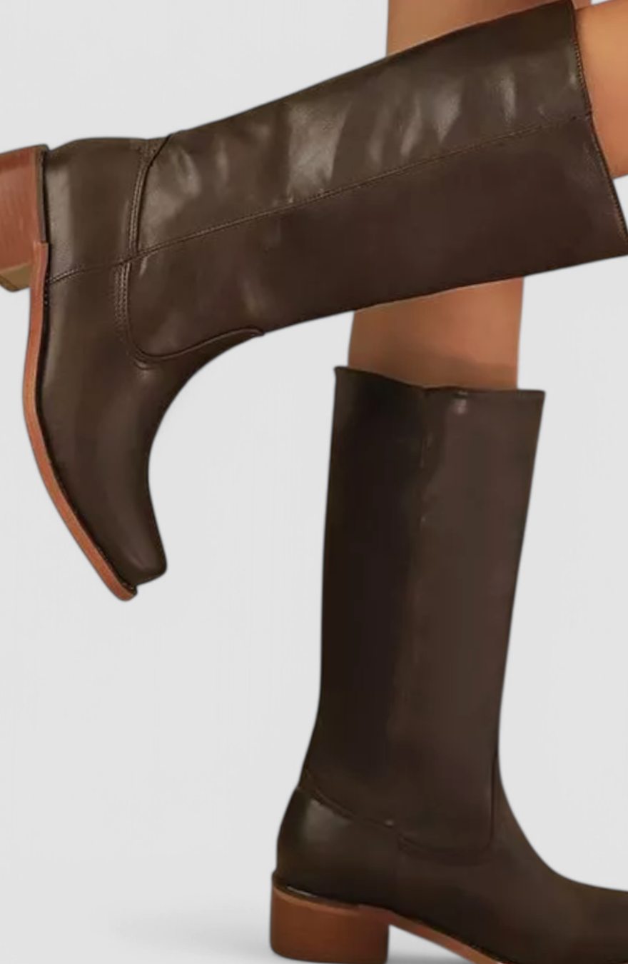 Botas de piel hasta la rodilla en color negro sobre fondo neutro
