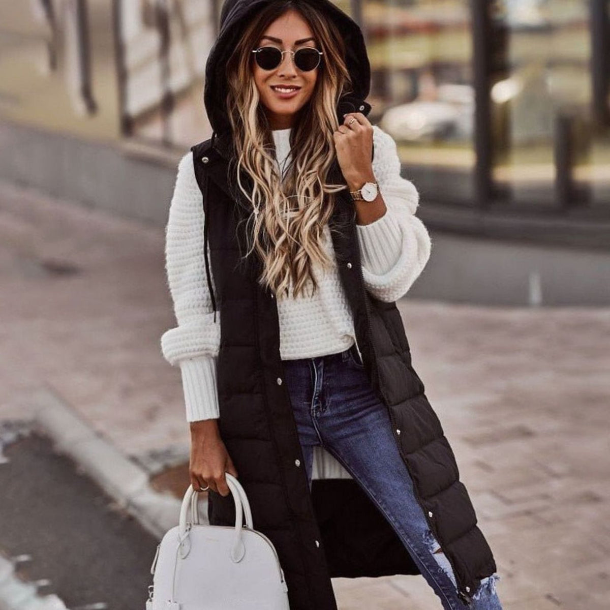 Mujer con chaleco largo acolchado con capucha en color negro, estilo invierno